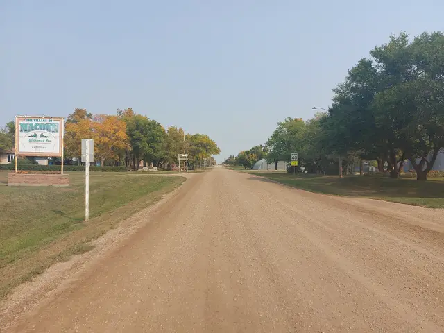 Gravel street and village welcome sign